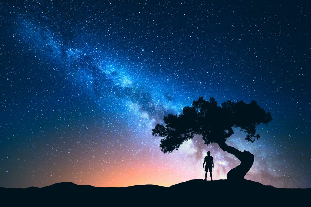 Milky Way, tree and silhouette of alone man. Night landscape