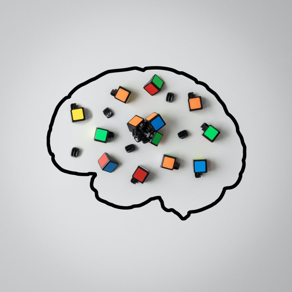 Concept of mental health. Silhouette of a human brain with a broken puzzle on a gray background.