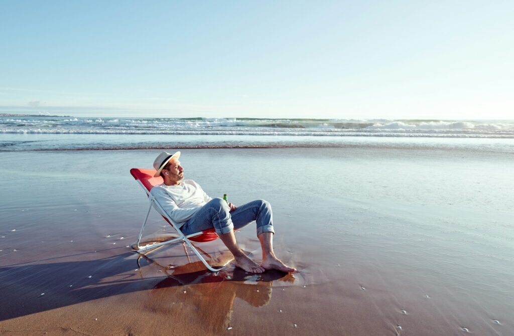 mature man lying on beach chair relaxed with eyes closed on the remote beach shore